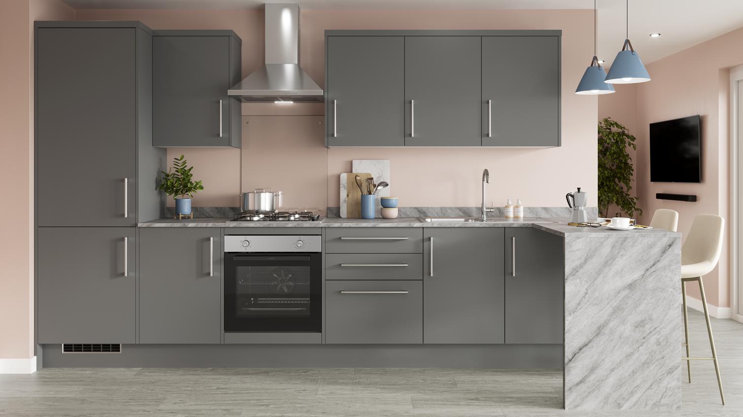 A modern grey kitchen in a l-shape layout with slab doors. Has a marble-effect breakfast bar, and a built-under oven.